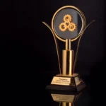 Gold-plated metal trophy with clear crystal and black base
